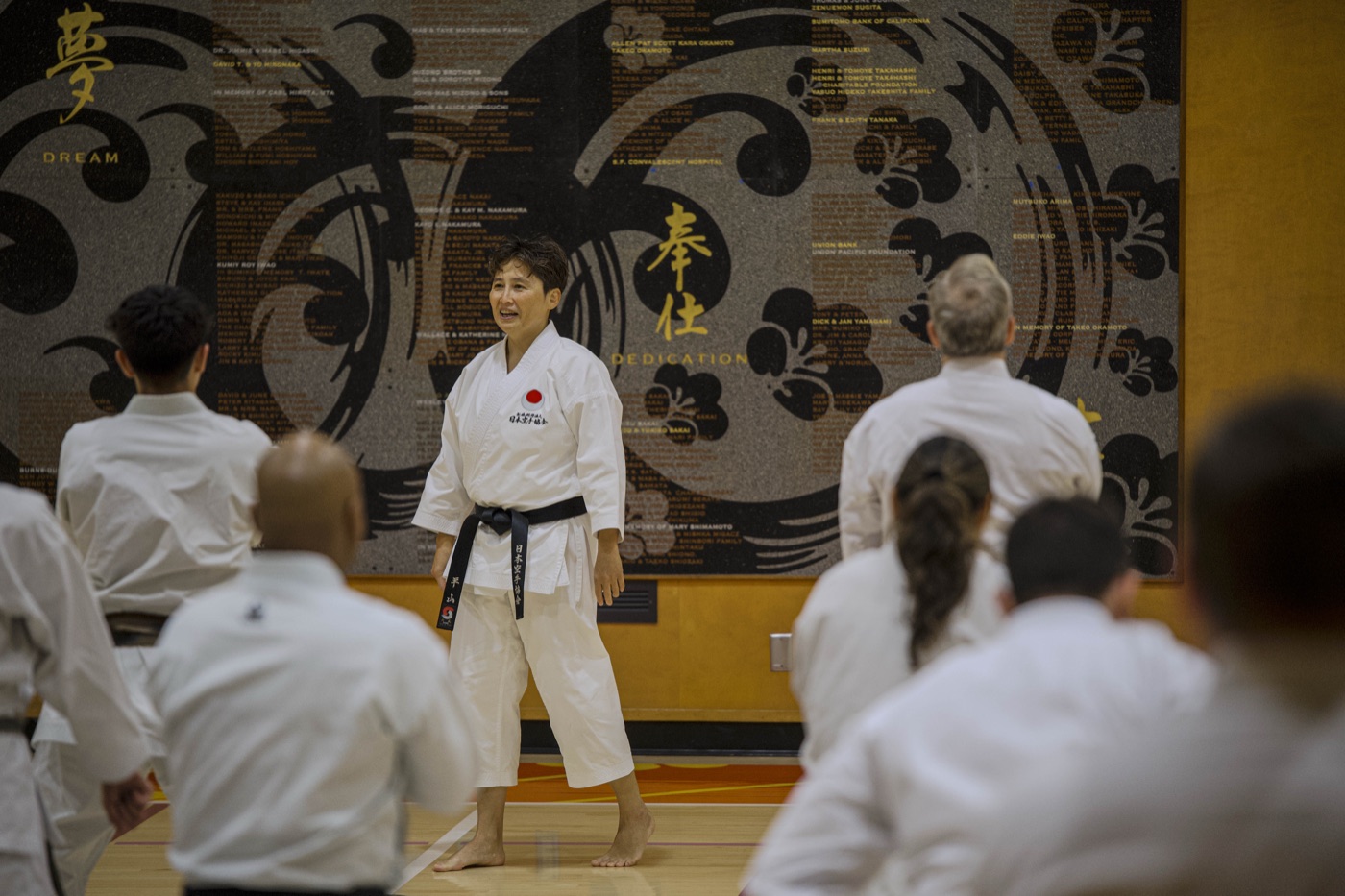 Sensei Hirayama leading a session in front of the dojo calligraphy wall